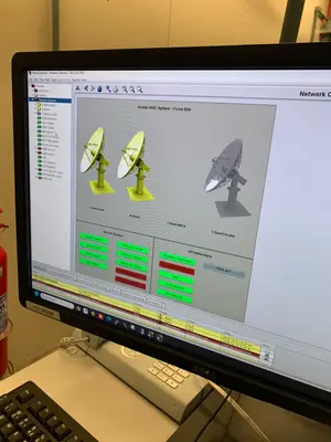Monitor do sistema de monitoramento e controle exibindo o status das antenas de satélite e dos servidores.